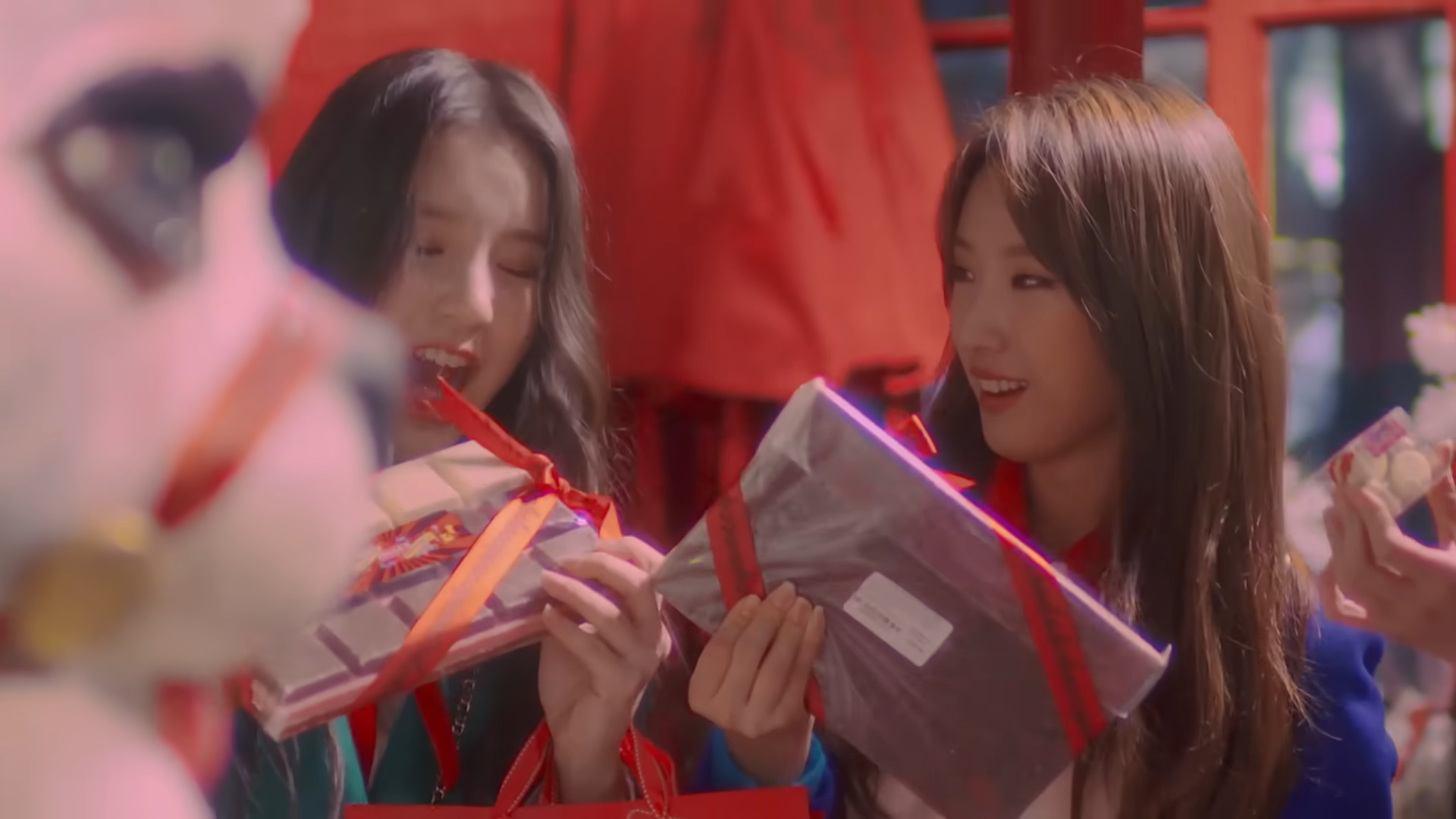 Heejin and Haseul holding wrapped chocolate.